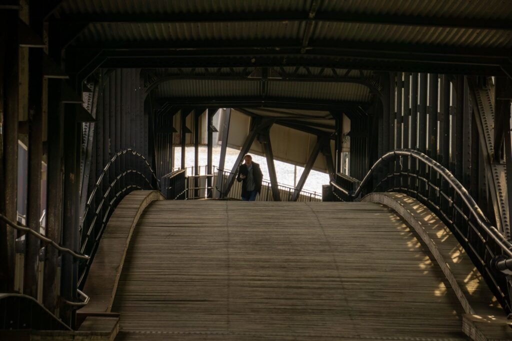 Inside view of a metal bridge in Hamburg with people walking, showcasing urban architecture.