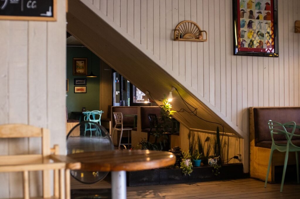 Inviting café interior with wooden decor, empty seats, and ambient lighting.