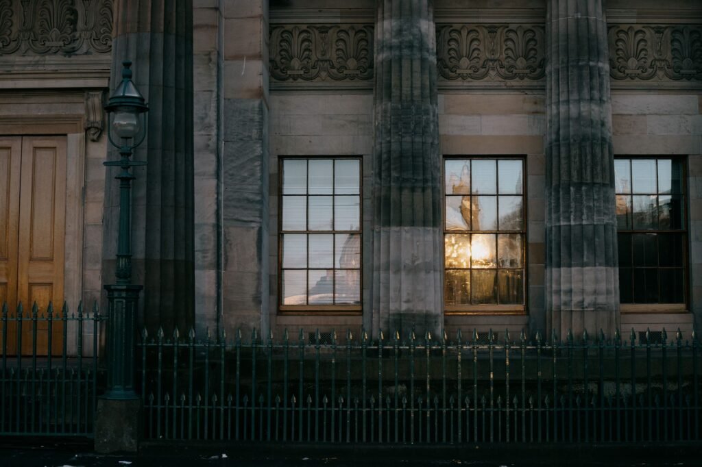 Facade of a neo-classical building in Edinburgh with reflections on windows.