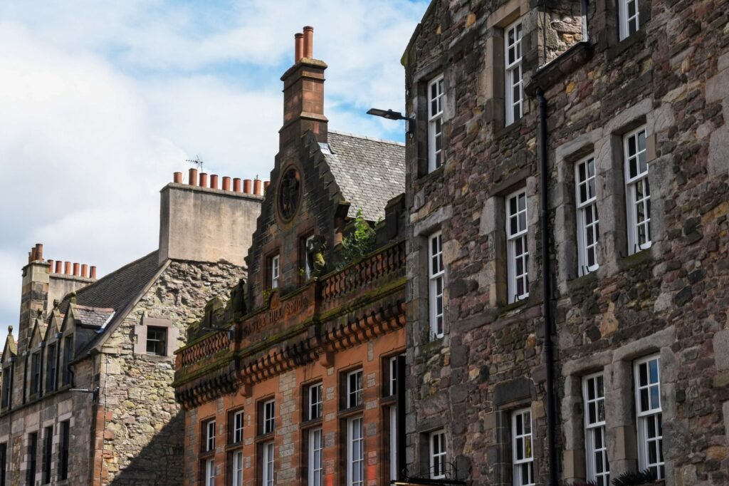 Stone facade buildings lining Edinburgh's iconic Royal Mile under a blue sky.