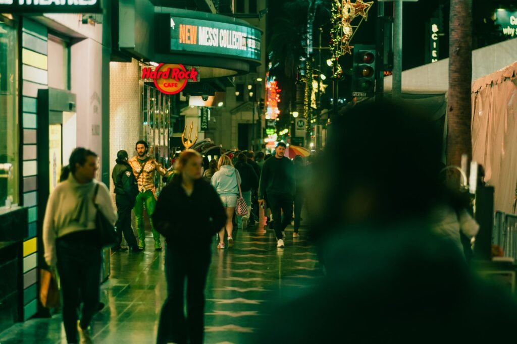 Crowded urban street scene at night with pedestrians and city lights.