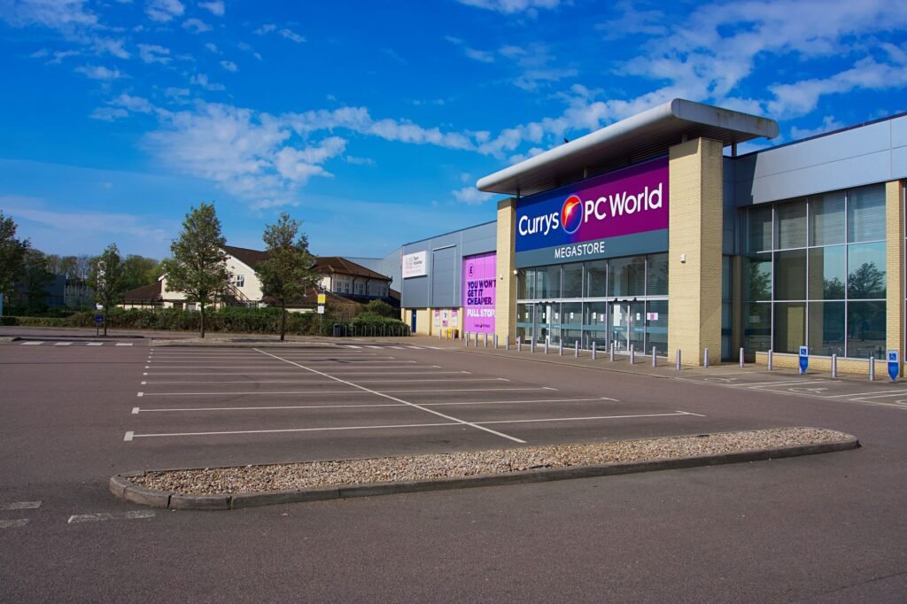 Empty parking lot outside Currys PC World megastore on a clear day in England.