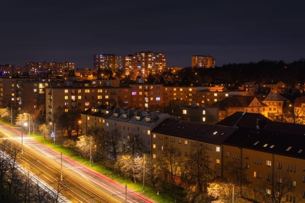 Discover the vibrant night cityscape of Prague enhanced with light trails and glowing windows.