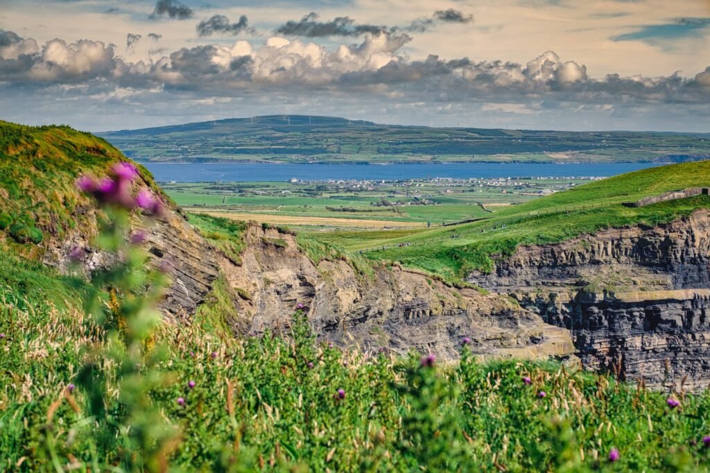 Beautiful scenic view of Irish cliffs and landscape with lush greenery and ocean in the background.