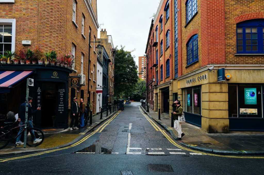 Picturesque street view of a narrow alley with classic London architecture full of vibrant life.