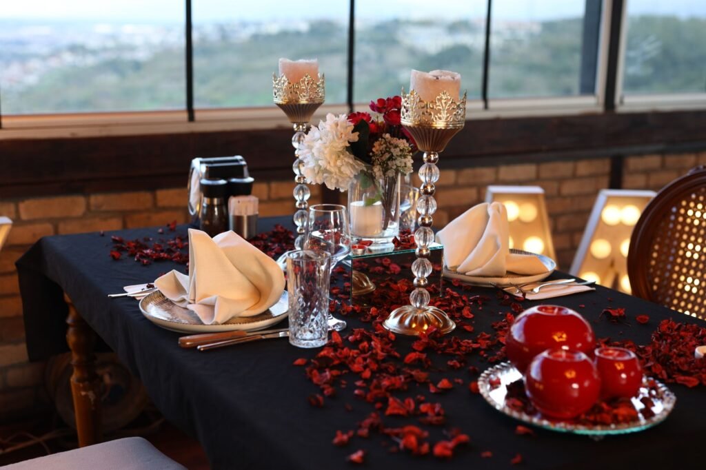 Elegant table setting with candles, flowers, and apples, ideal for romantic dining.