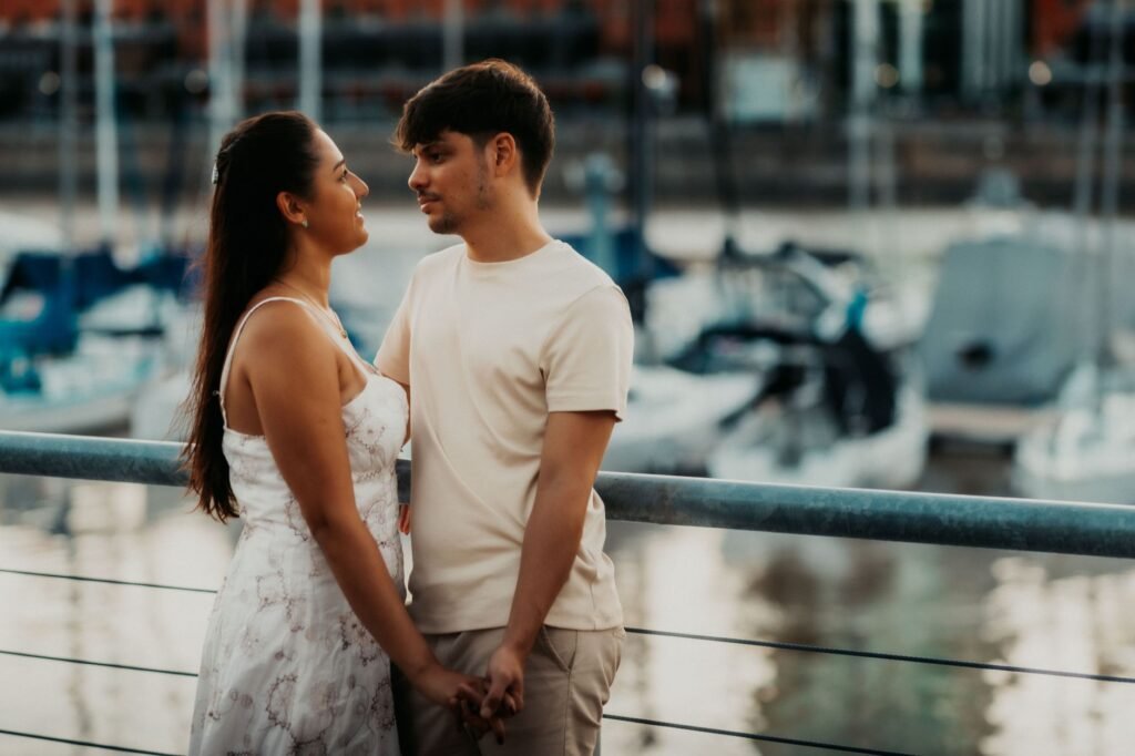 Romantic couple holding hands by the harbor in Buenos Aires at sunset.