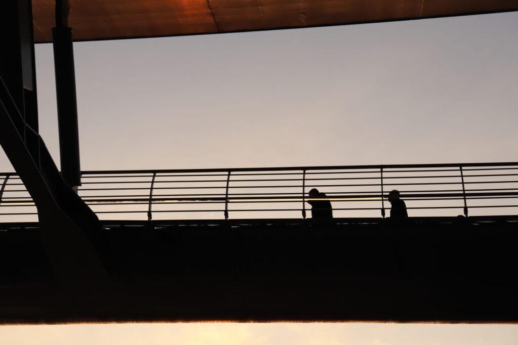 Silhouettes walking on the Halic Bridge against a sunset sky in Istanbul, Turkey.