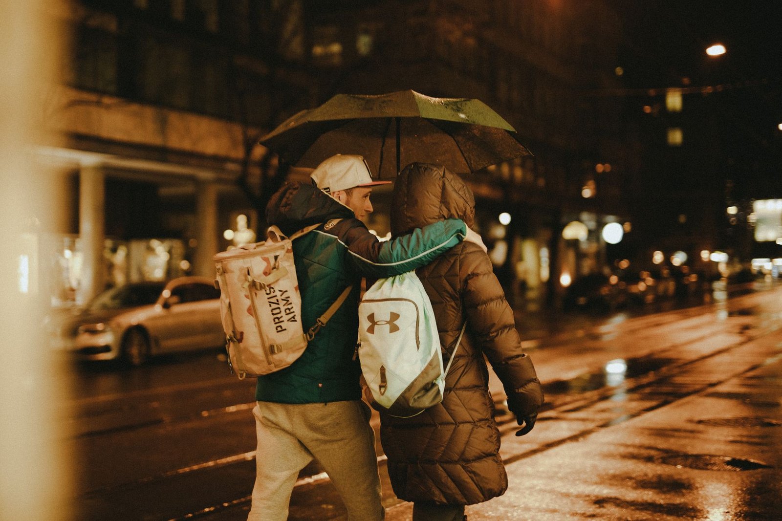 A couple walking under an umbrella on a rainy night in Zürich, Switzerland.