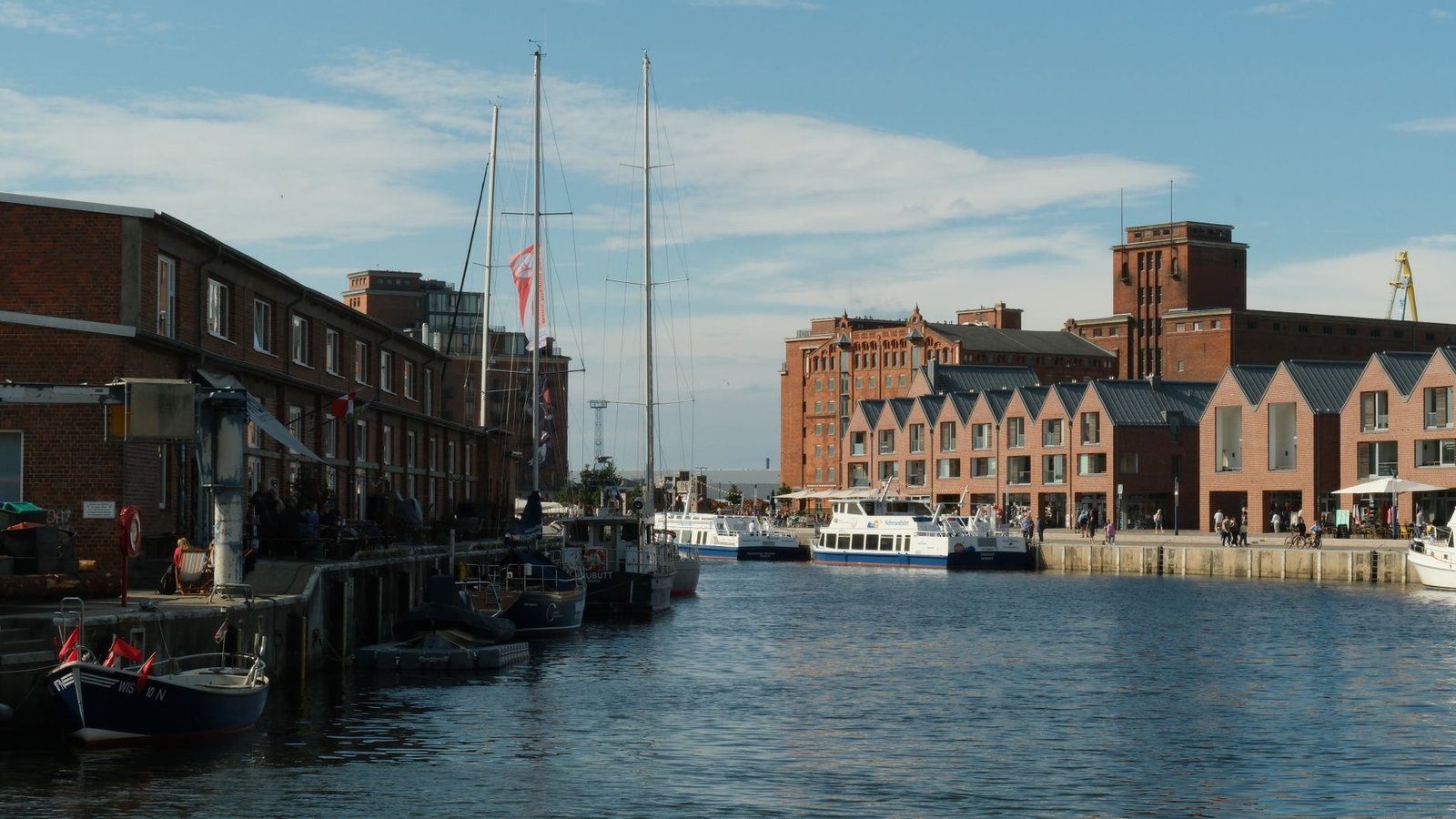 Explore Wismar's vibrant old harbor with red brick architecture and sailing boats.