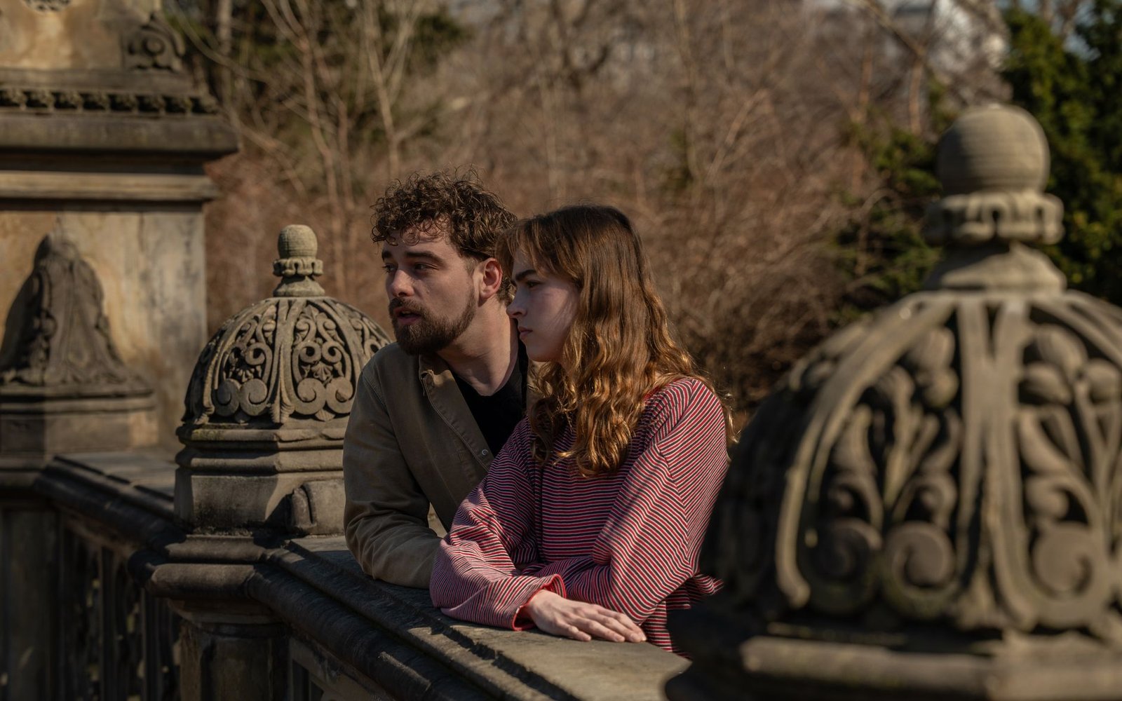 A couple shares a moment on a historic Central Park bridge in New York City in the afternoon.