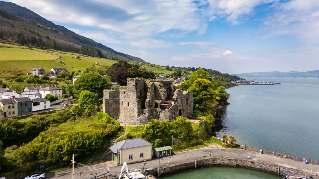 Aerial view of historic Greenore Castle ruins by the sea in Ireland.