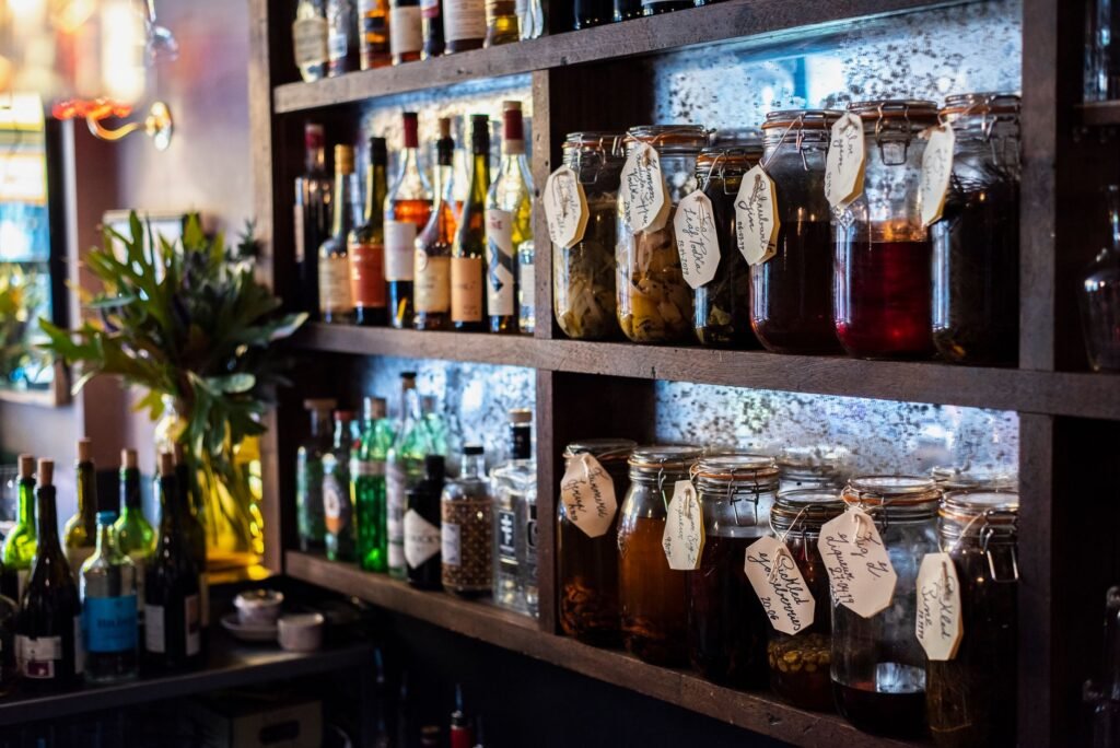 Explore a charming London bar with shelves of diverse bottles and labeled jars, capturing its inviting ambiance.