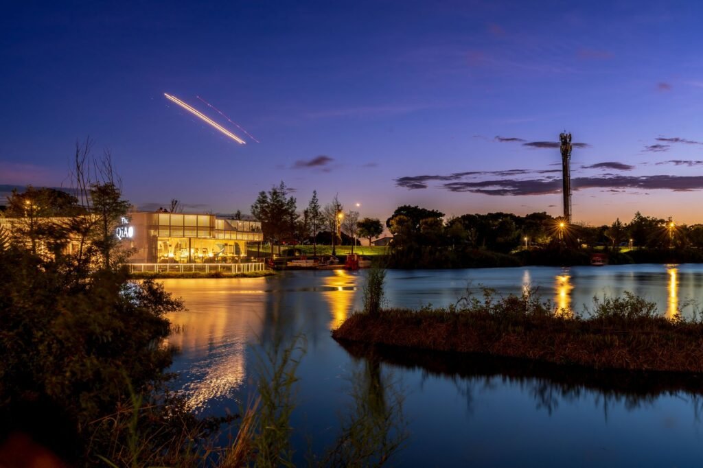 Peaceful waterfront dining with evening reflections and clear night sky.