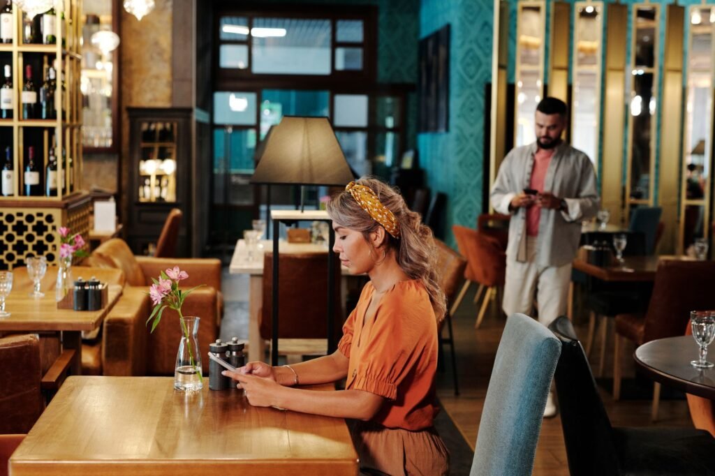 Two individuals engrossed in smartphones at a stylish cafe.