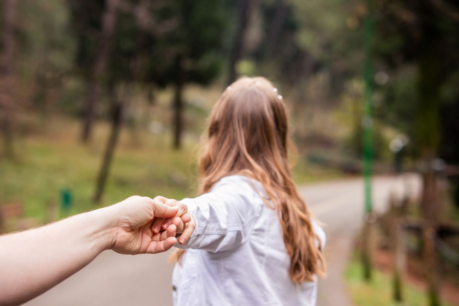 A young woman explores a park in Podgoriţa, Montenegro while holding hands, symbolizing adventure.