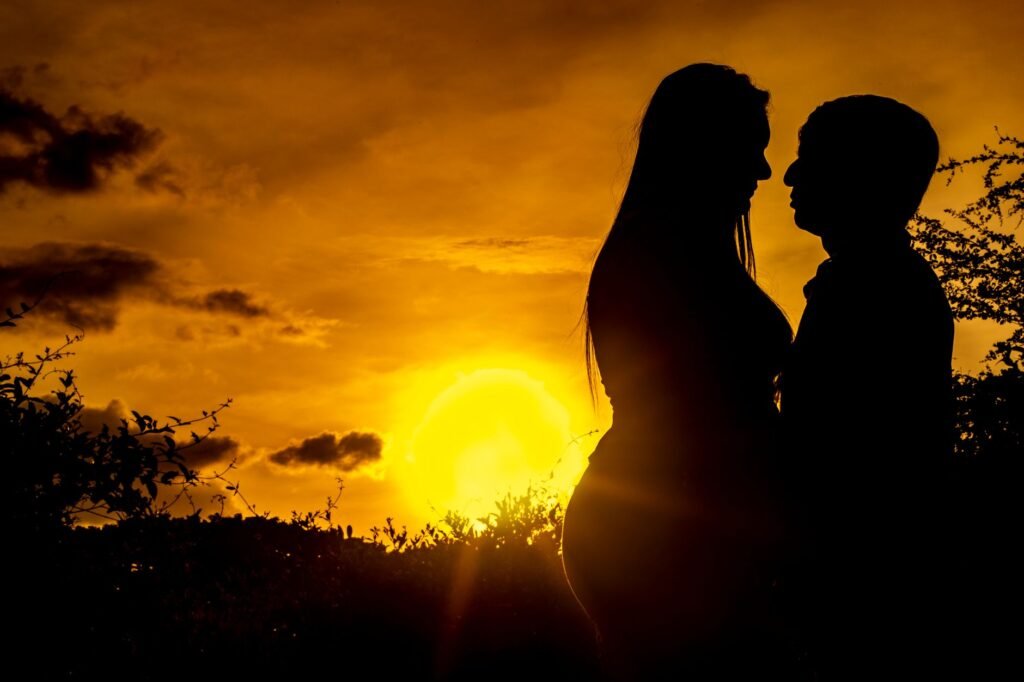 Silhouette of a couple embracing at a golden sunset in San Pelayo, Colombia.