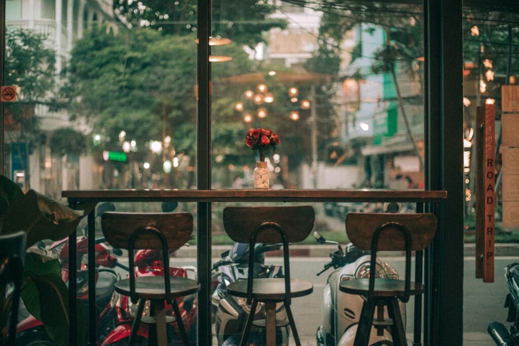 A cozy café in Ho Chi Minh City featuring a view of bustling streets with scooters.