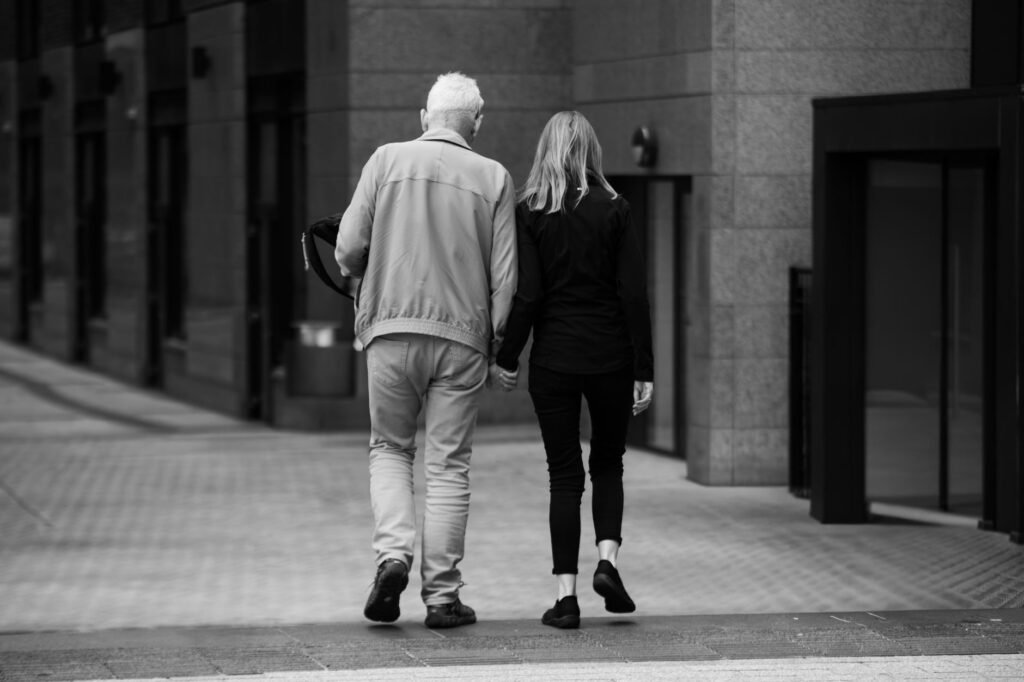 A heartwarming scene of a senior couple holding hands and walking in Dublin's urban setting.