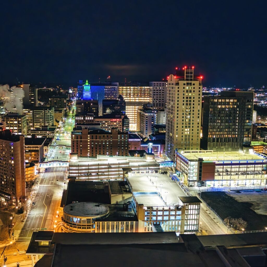 Stunning aerial view of downtown Rochester, MN at night showcasing illuminated buildings and city lights.