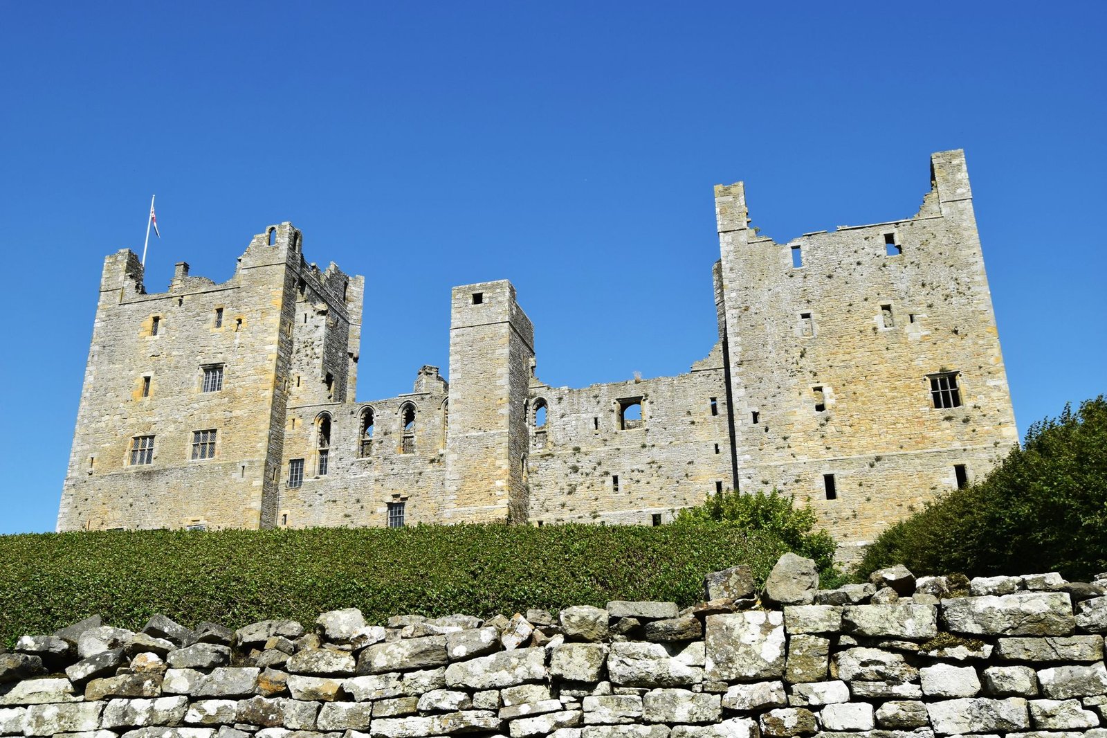 View of the medieval Castle Bolton in England, showcasing Gothic architecture on a sunny day.