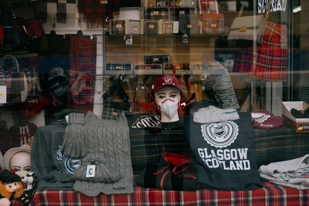 A storefront display in Glasgow showcasing Scottish-themed clothing and accessories.