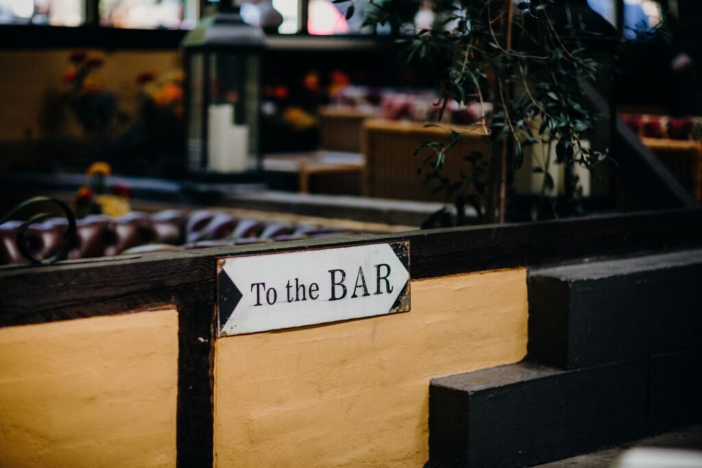 A close-up view of a 'To the BAR' sign in a warmly lit indoor lounge area.