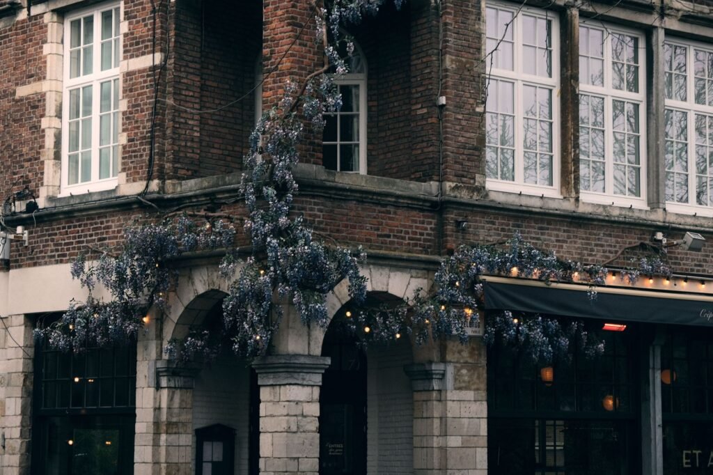 A picturesque vintage café in Ghent draped with blooming wisteria, capturing European charm.