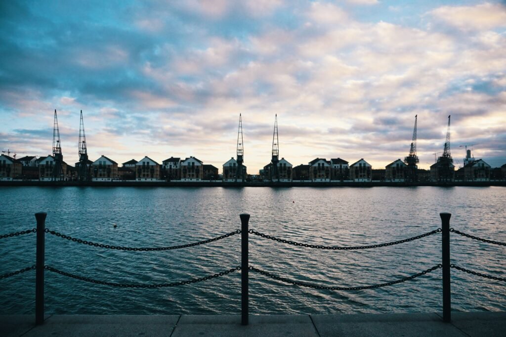 Captured from the London Docklands, showcasing the serene waterfront and industrial skyline at dusk.