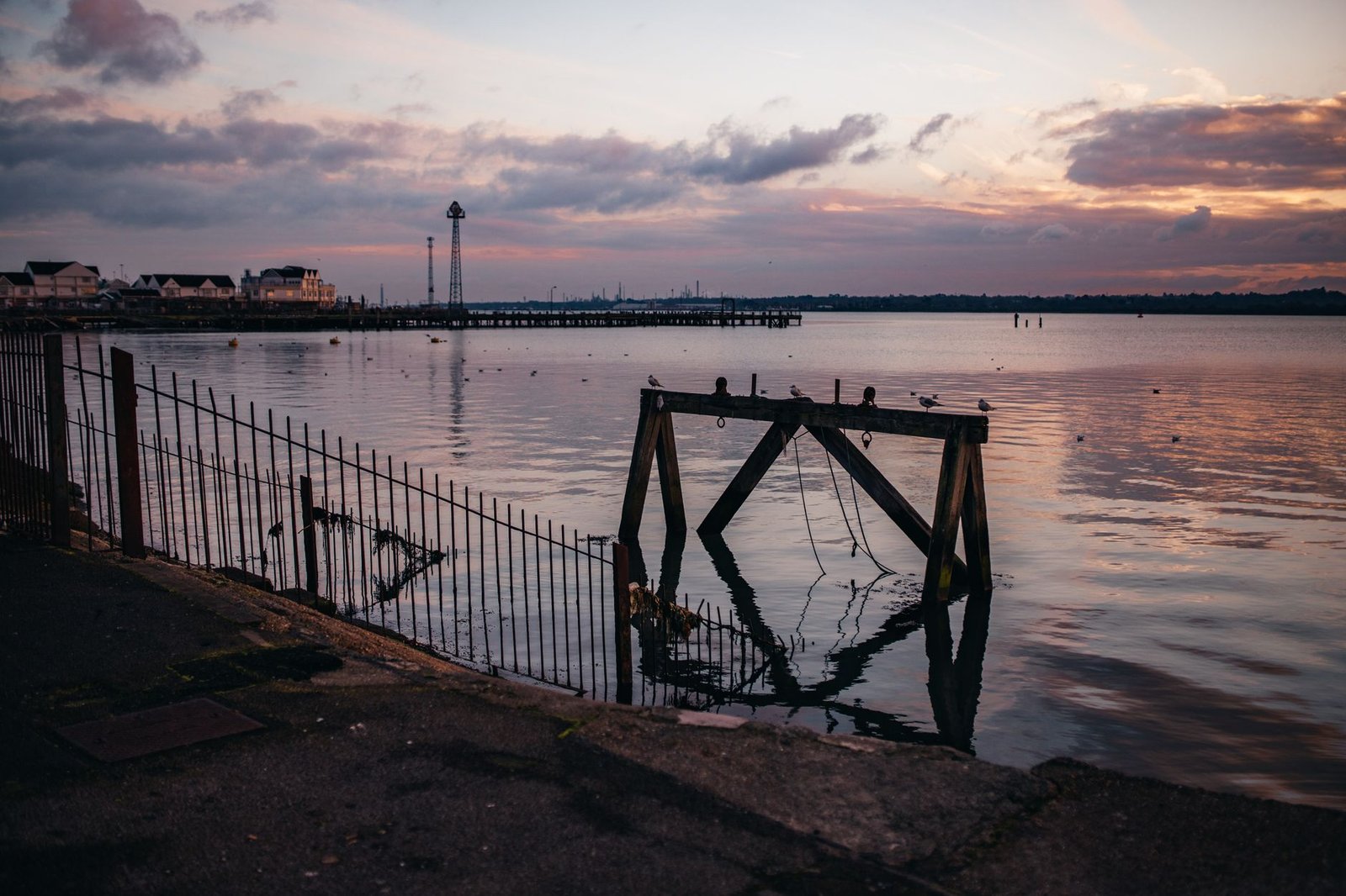 Peaceful sunset over a seaside with reflections and gentle waves.