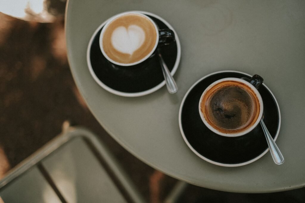 Top view of a cappuccino with latte art and a black coffee on a table. Perfect for coffee lovers.