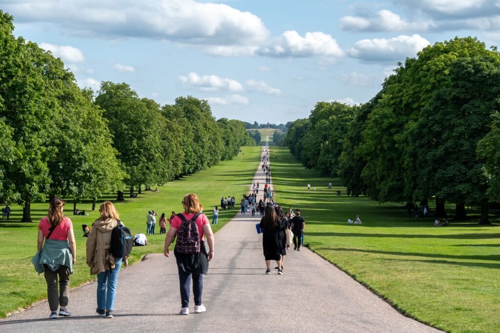 People enjoying a sunny walk along the Long Walk in Windsor Great Park, England.