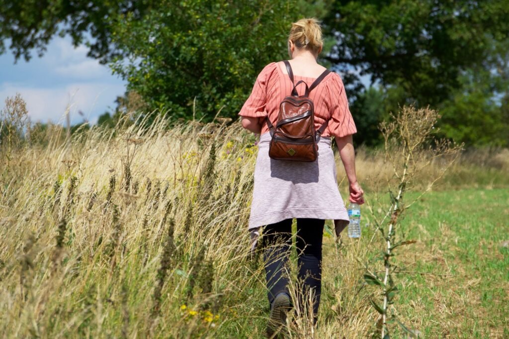 A serene countryside walk in the UK with a woman enjoying a peaceful outdoor stroll.