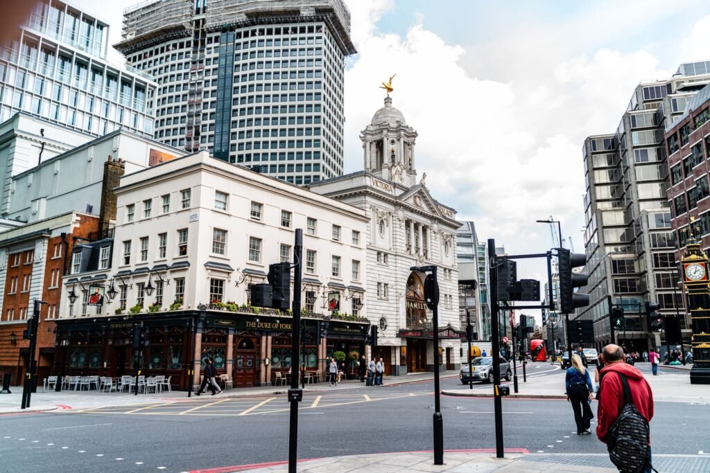 Street view of the iconic Victoria Palace Theatre and nearby buildings in London, England.