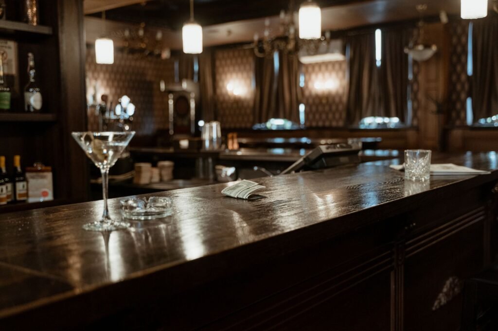 A cozy bar counter with cocktail glasses and dim lighting, inviting ambiance.