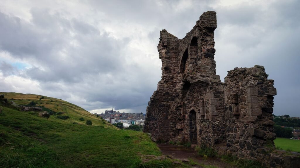 Historic ruins with a view of Edinburgh, Scotland's iconic skyline.