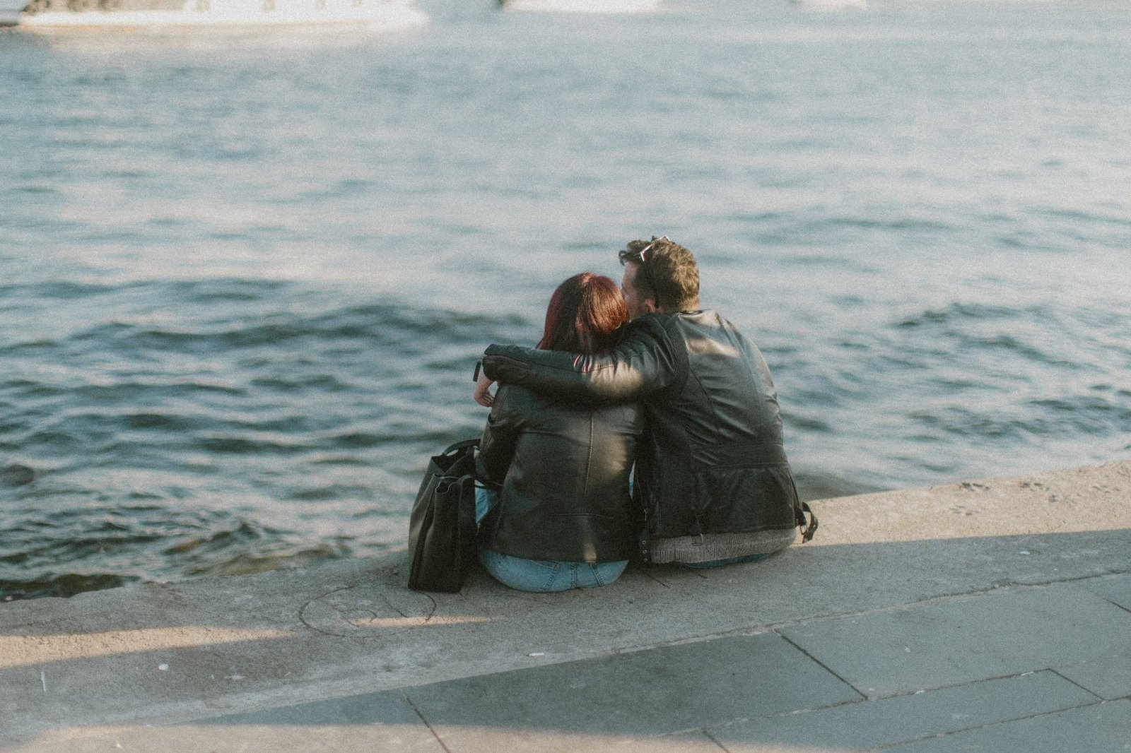 Couple seated by the Bosphorus in Istanbul, sharing a moment by the waterfront.