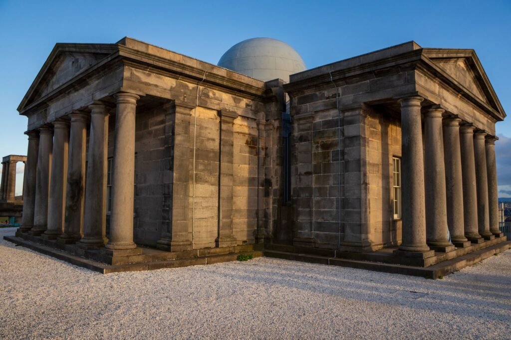 A grand stone observatory building with columns, captured at sunset.