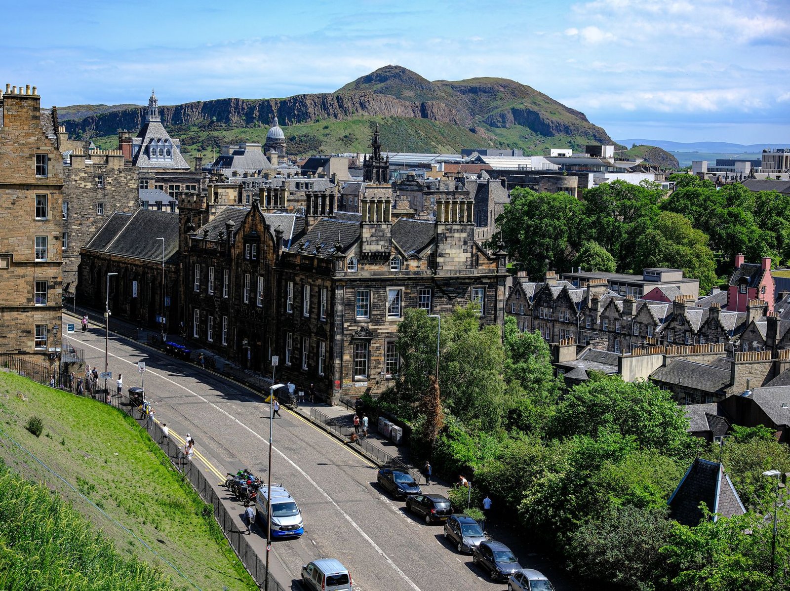 Panoramic view of historic Edinburgh architecture with Arthur's Seat in the background.