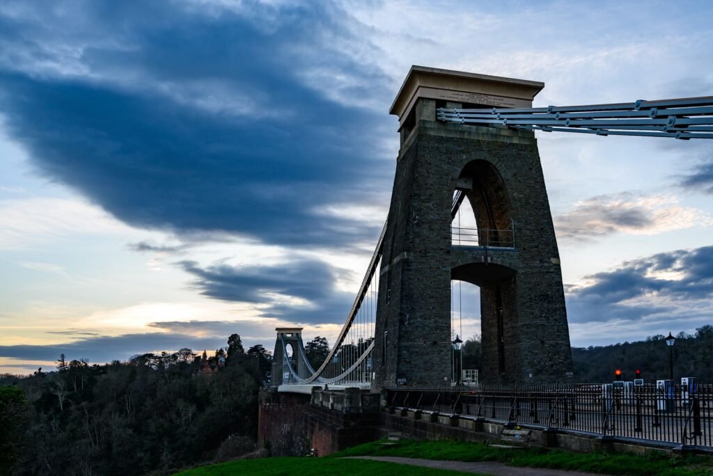 Iconic Clifton Suspension Bridge in Bristol, UK, photographed under a dramatic evening sky.