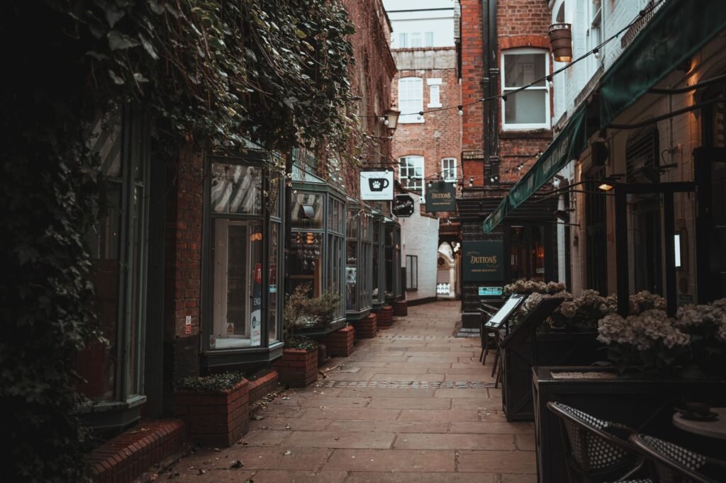 Explore a quaint alley with vintage shops and cafes, showcasing historic architecture.