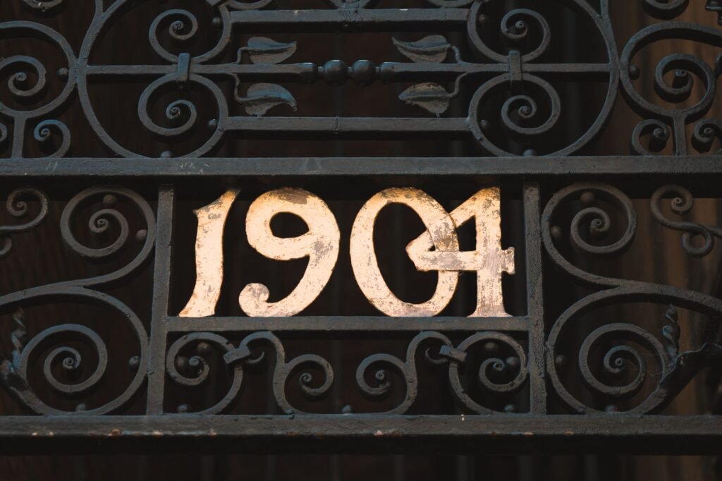 Decorative iron gate featuring the year 1904, showcasing vintage design in London.