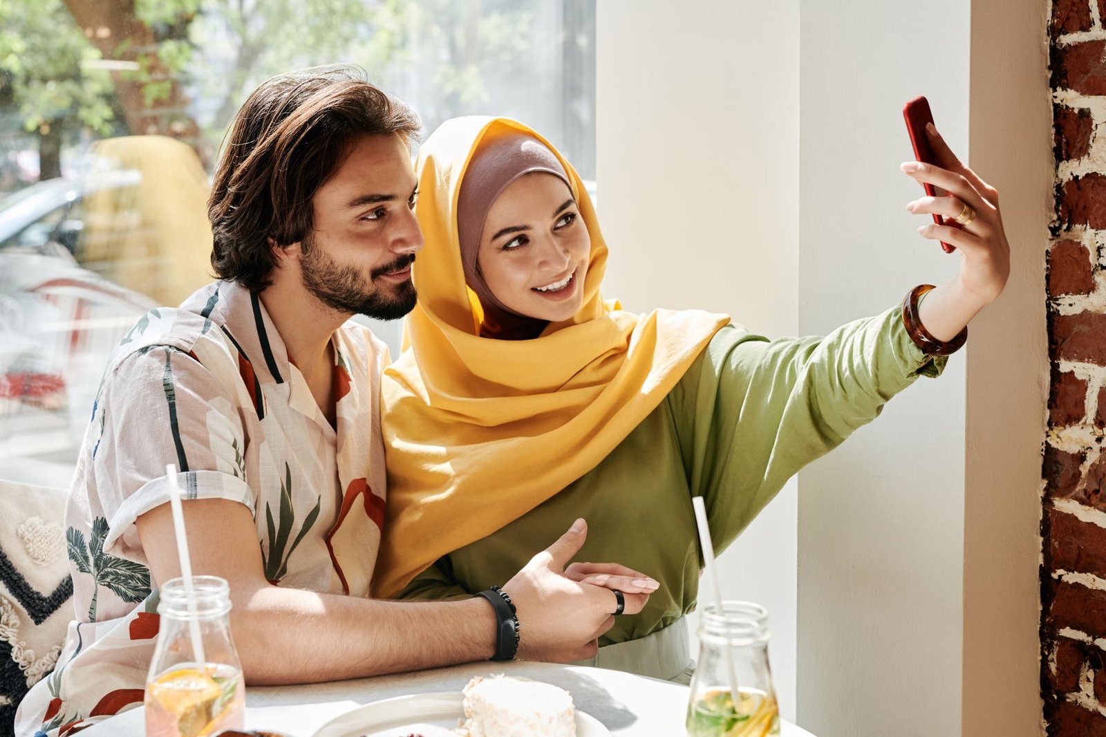 Young couple enjoying a date in a café, capturing a selfie together.