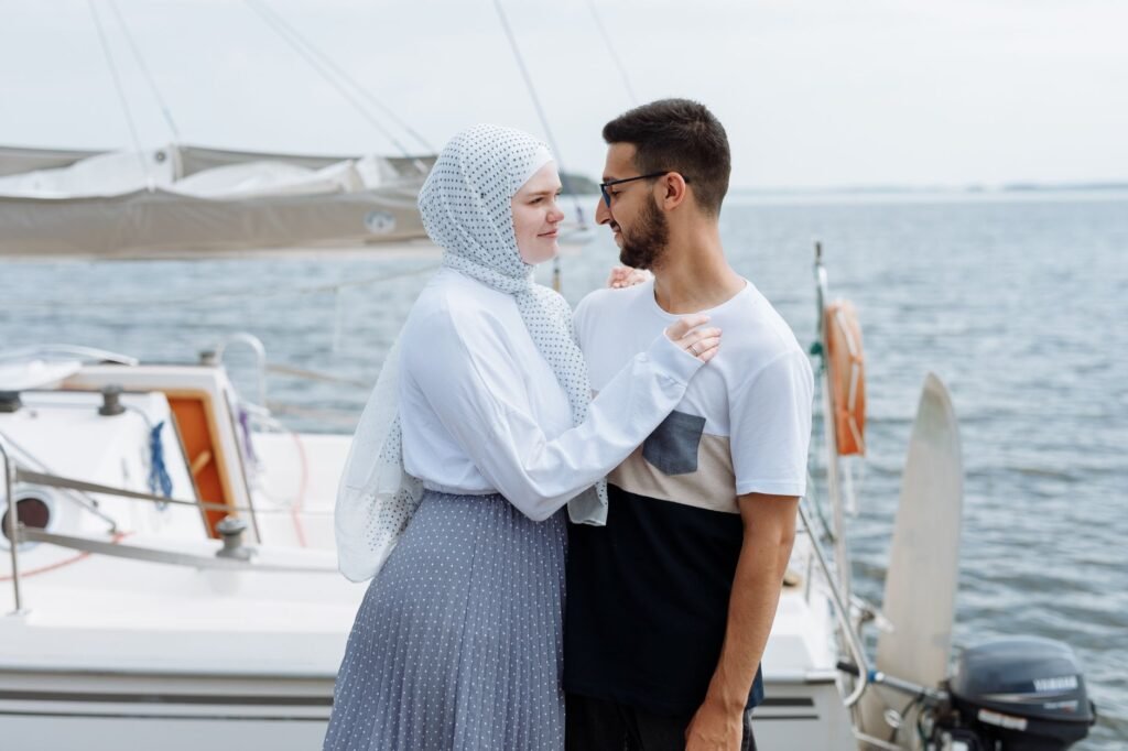 A loving couple enjoying a moment together on a sailing boat by the sea.