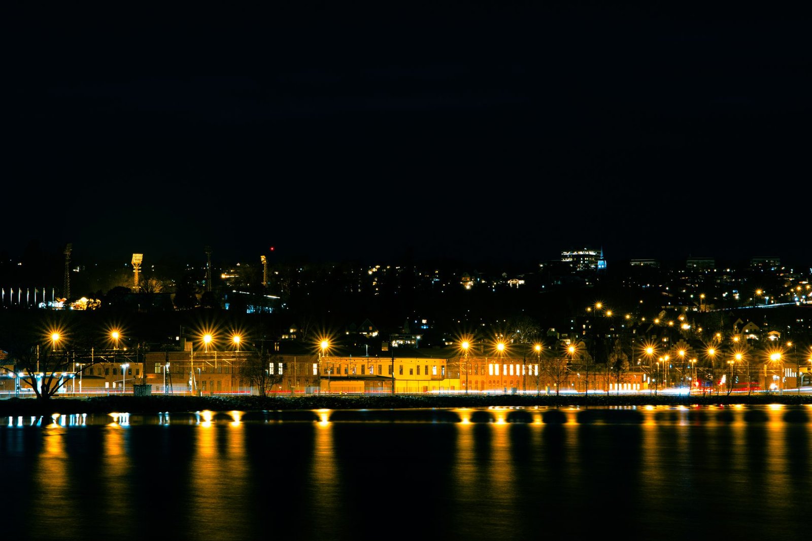Stunning night view of Jönköping, Sweden, with city lights reflecting on water.