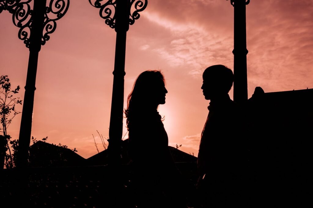 Silhouette of a couple gazing into each other's eyes during a picturesque sunset.