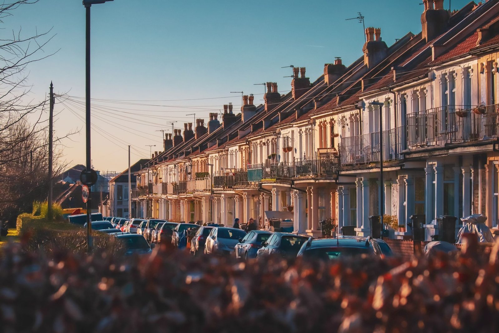 A picturesque street view of row townhouses with parked cars in soft afternoon light.