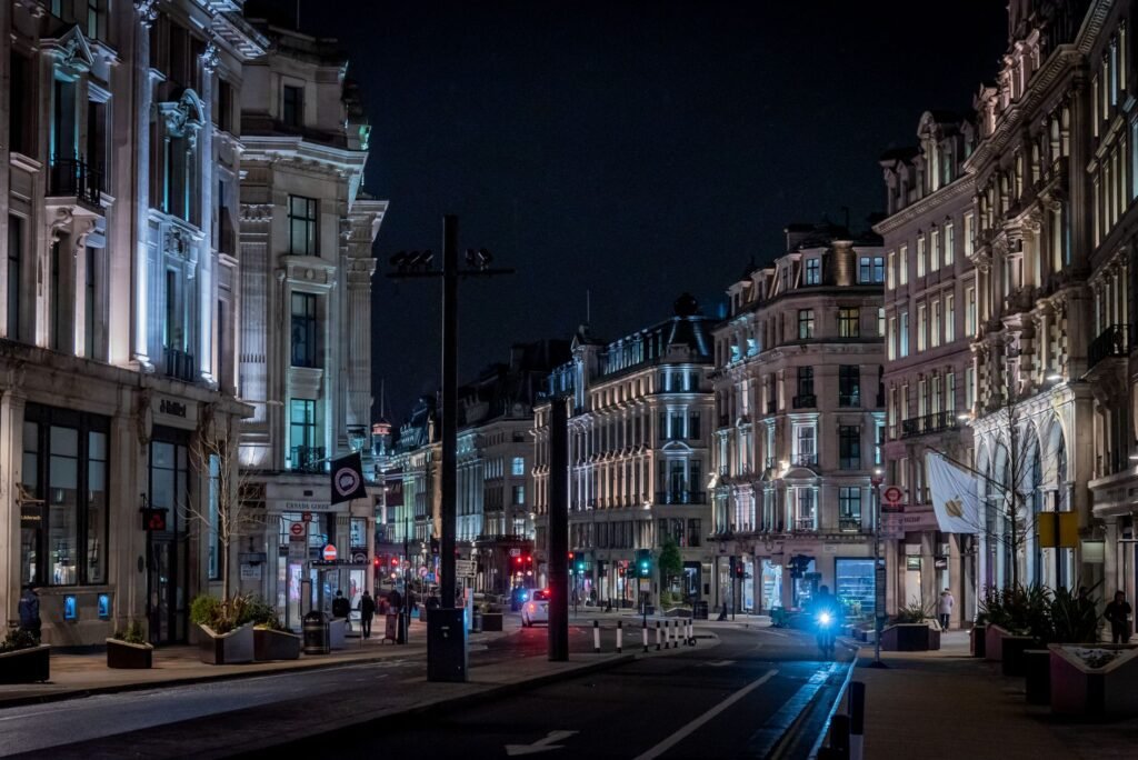 Illuminated buildings at night on Regent Street, London, showcasing classic architecture.