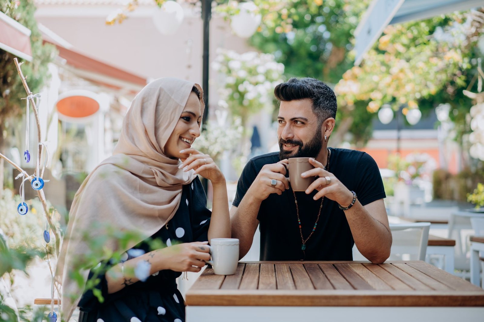 A romantic couple enjoying coffee together at an outdoor café.