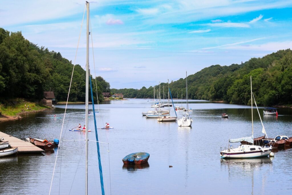 Idyllic river scene with boats and lush greenery in England, perfect for travel and nature themes.